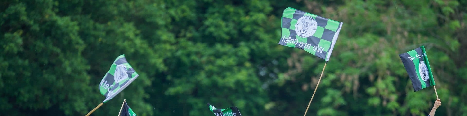 Celtic FC 1995 supporters waving green and black club flags on match day