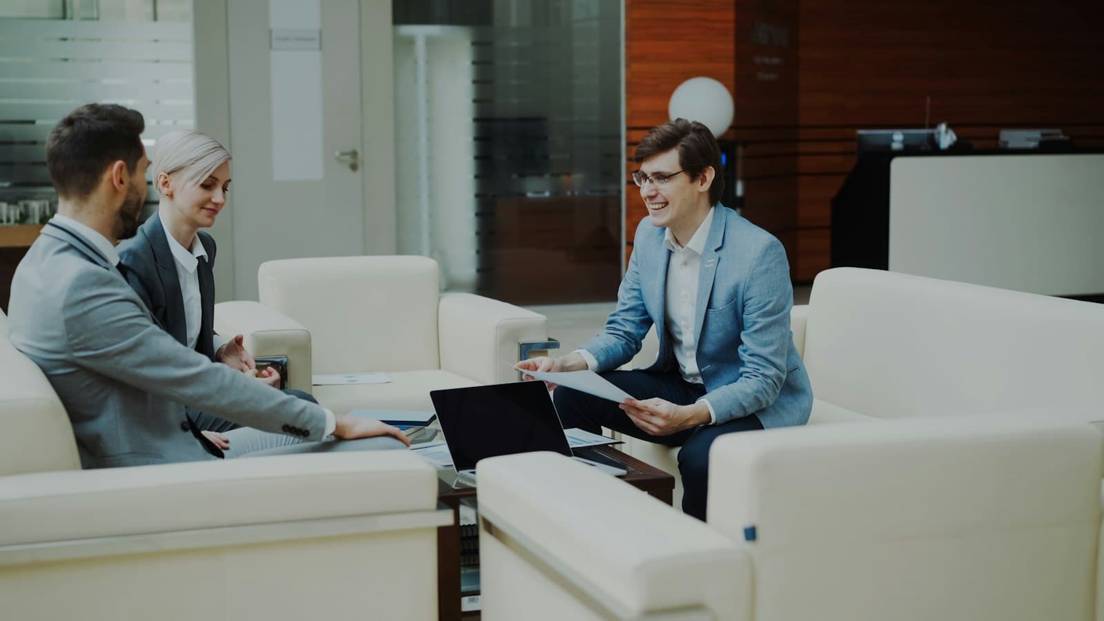 A business adviser talking through documents with two clients