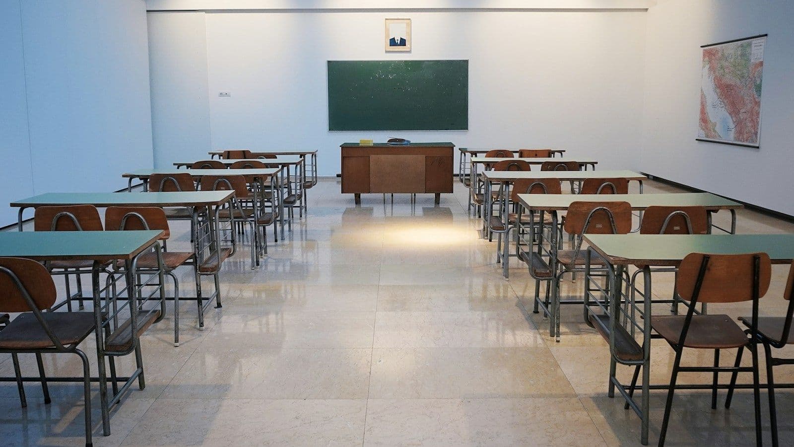 A classroom with rows of desks facing a chalkboard